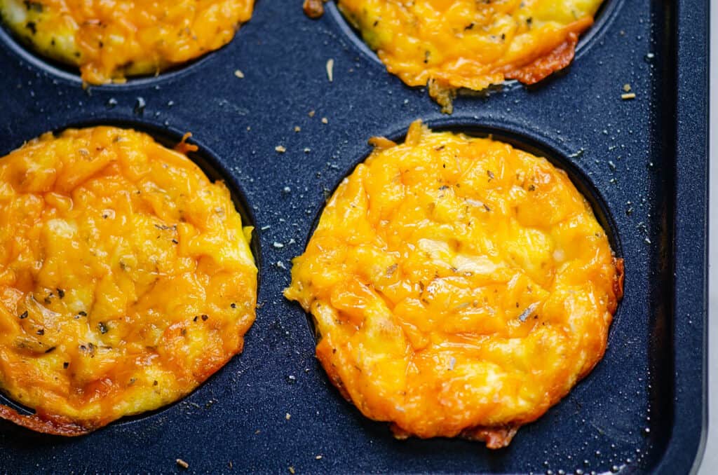 cheesy egg bites in blue muffin tin