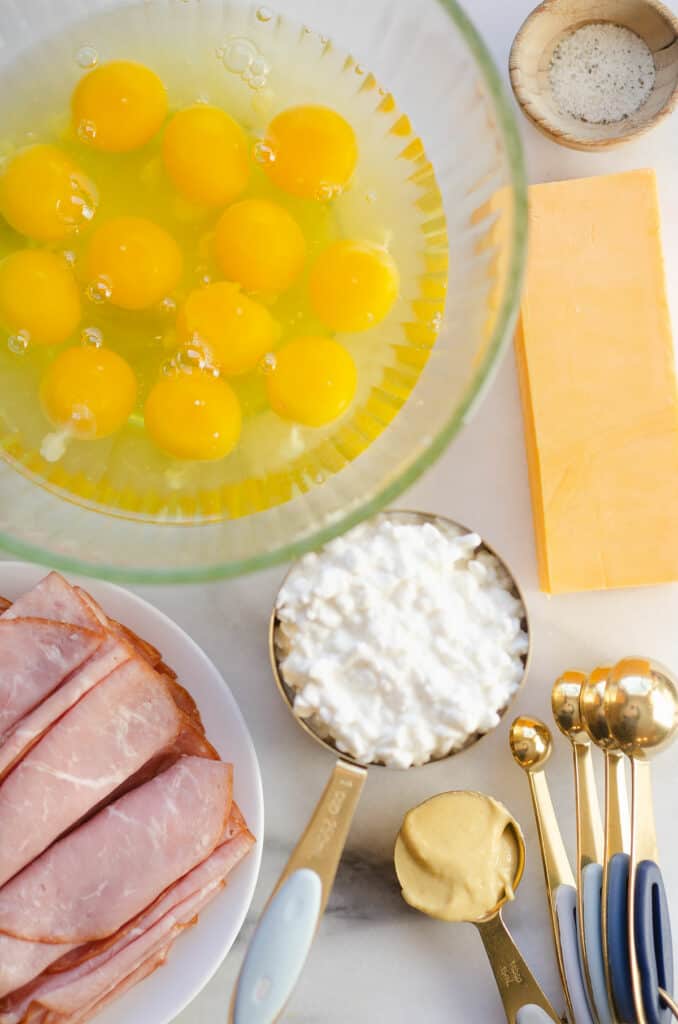 ham, eggs, cottage cheese, Dijon and cheddar on marble table