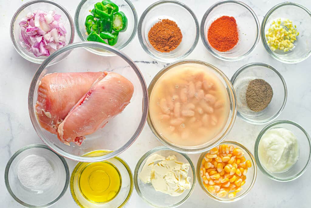 chicken soup ingredients in glass bowls on table