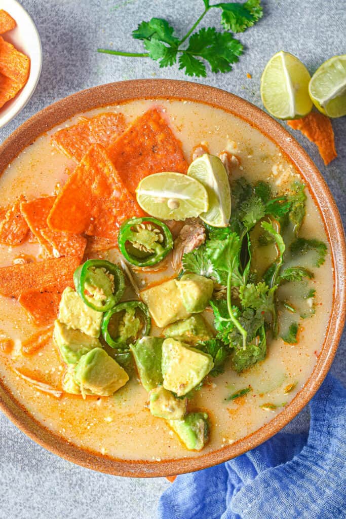 bowl of chicken jalapeno corn soup topped with chips and cilantro