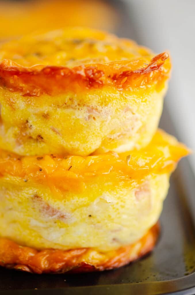 cheesy egg bites stacked on muffin tin