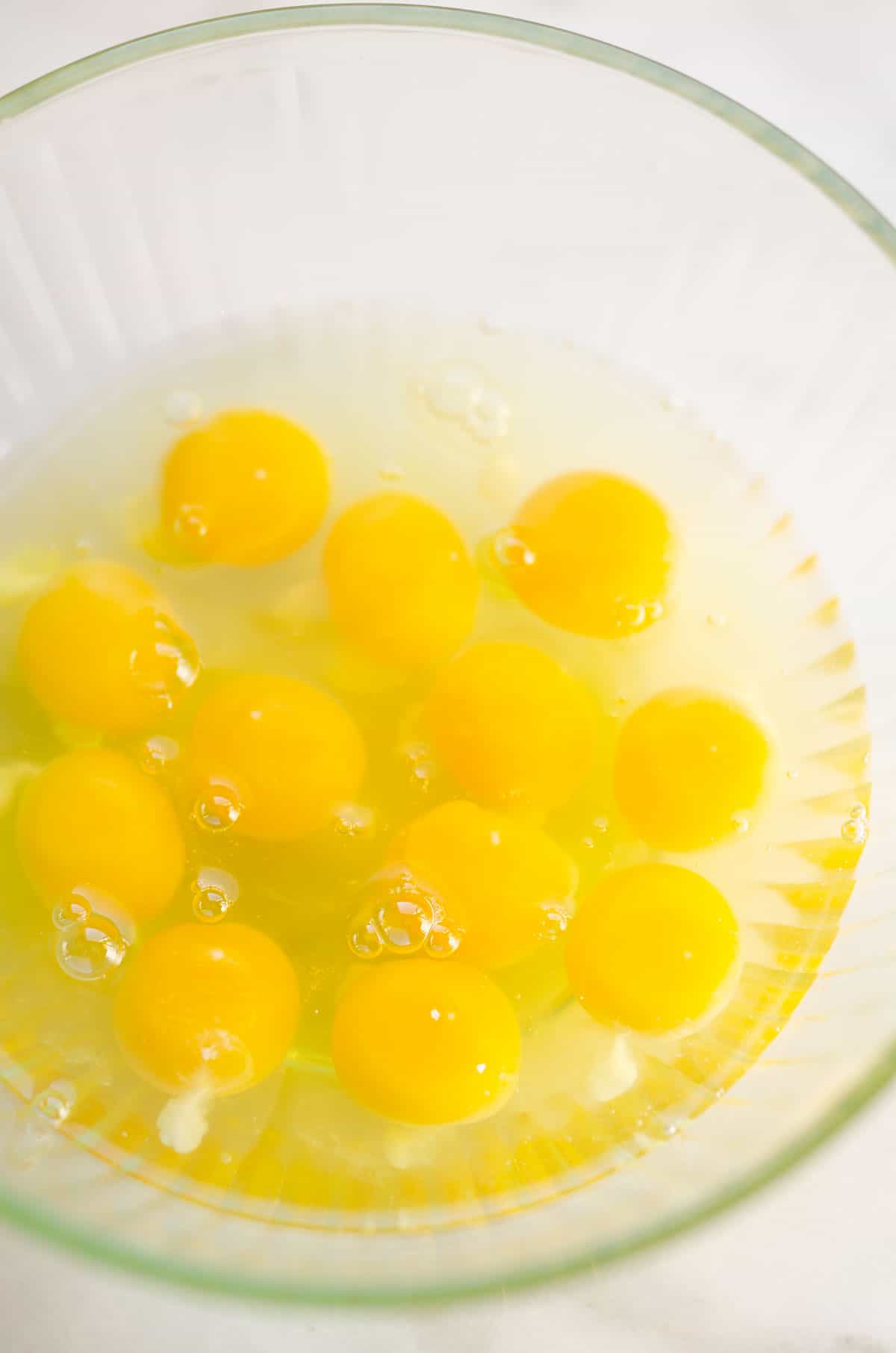 dozen of eggs cracked in glass bowl