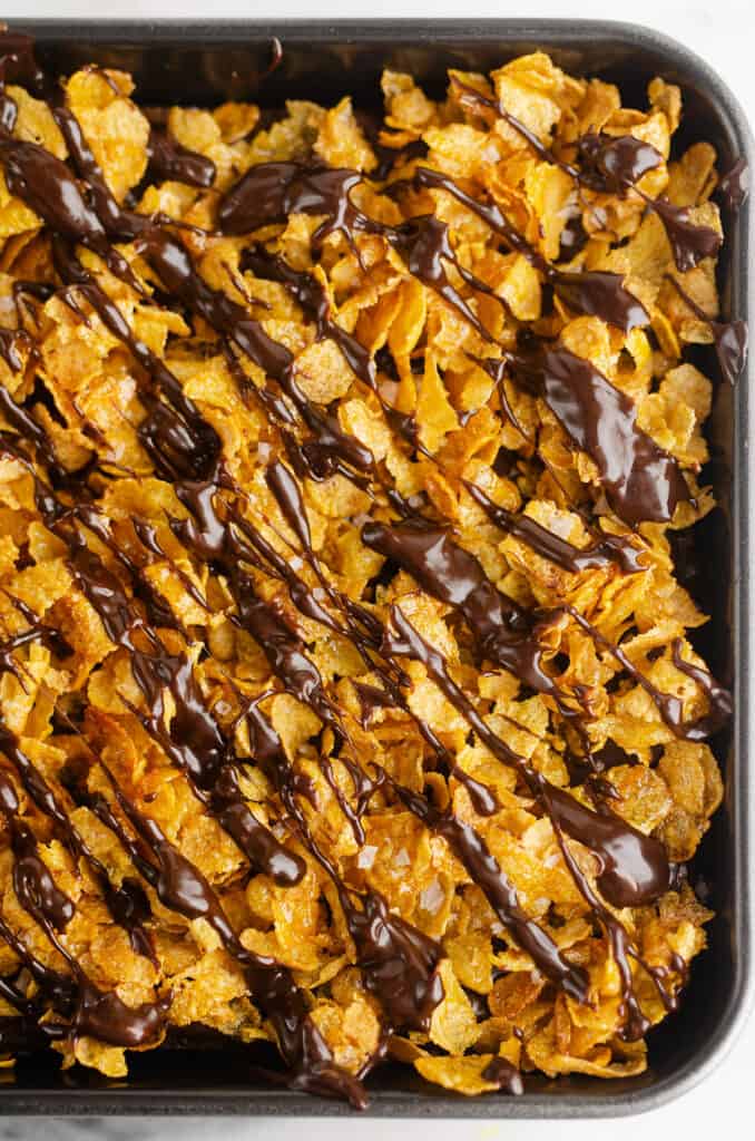 pan of cornflake dessert brownies in 9x9 pan drizzled with ganache