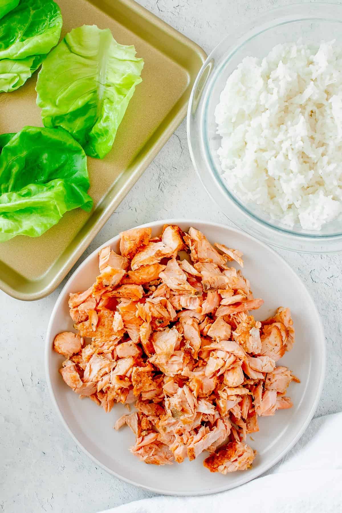 salmon tossed in teriyaki sauce in bowl with lettuce and white rice