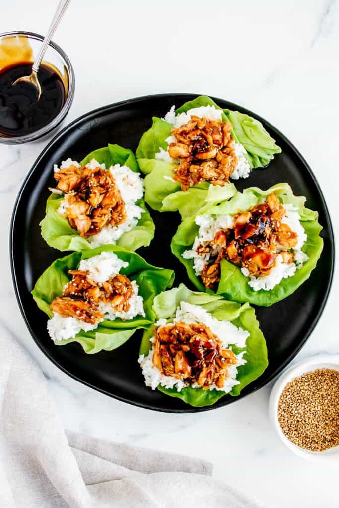 leftover salmon, teriyaki and rice lettuce cups on black plate with sesame seeds