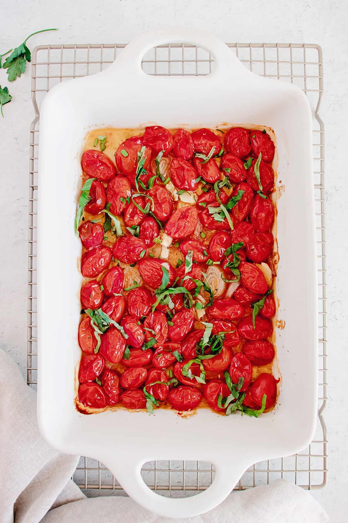 roasted tomatoes and garlic in white baking dish on cooling rack