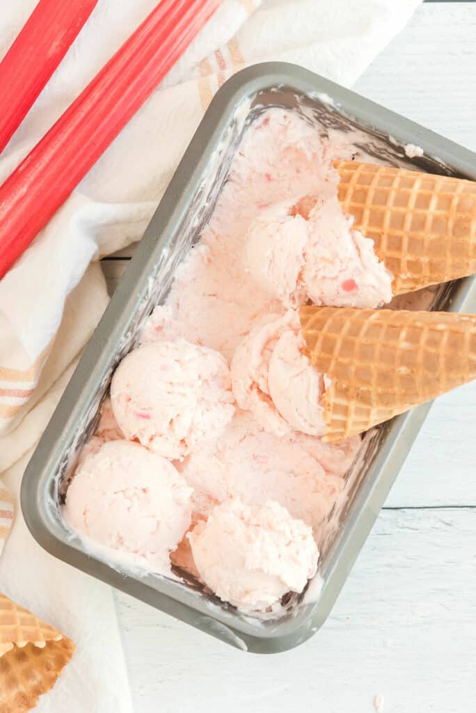 rhubarb ice cream cones with scoops in loaf pan of ice cream