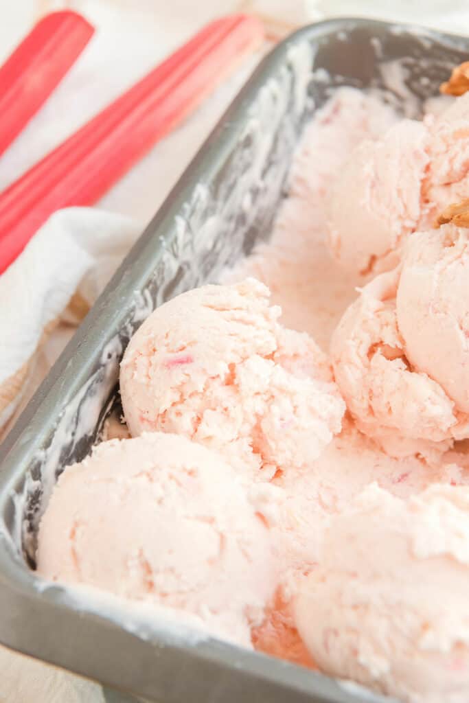 scoops of rhubarb ice cream in loaf pan on top of pan