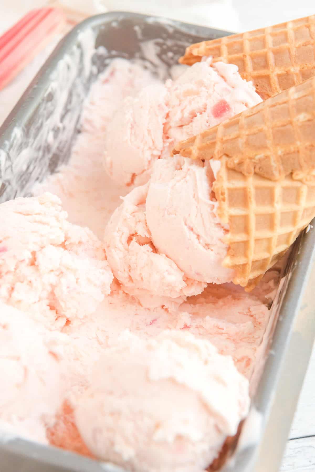 waffle cones with scoops of rhubarb ice cream in pan