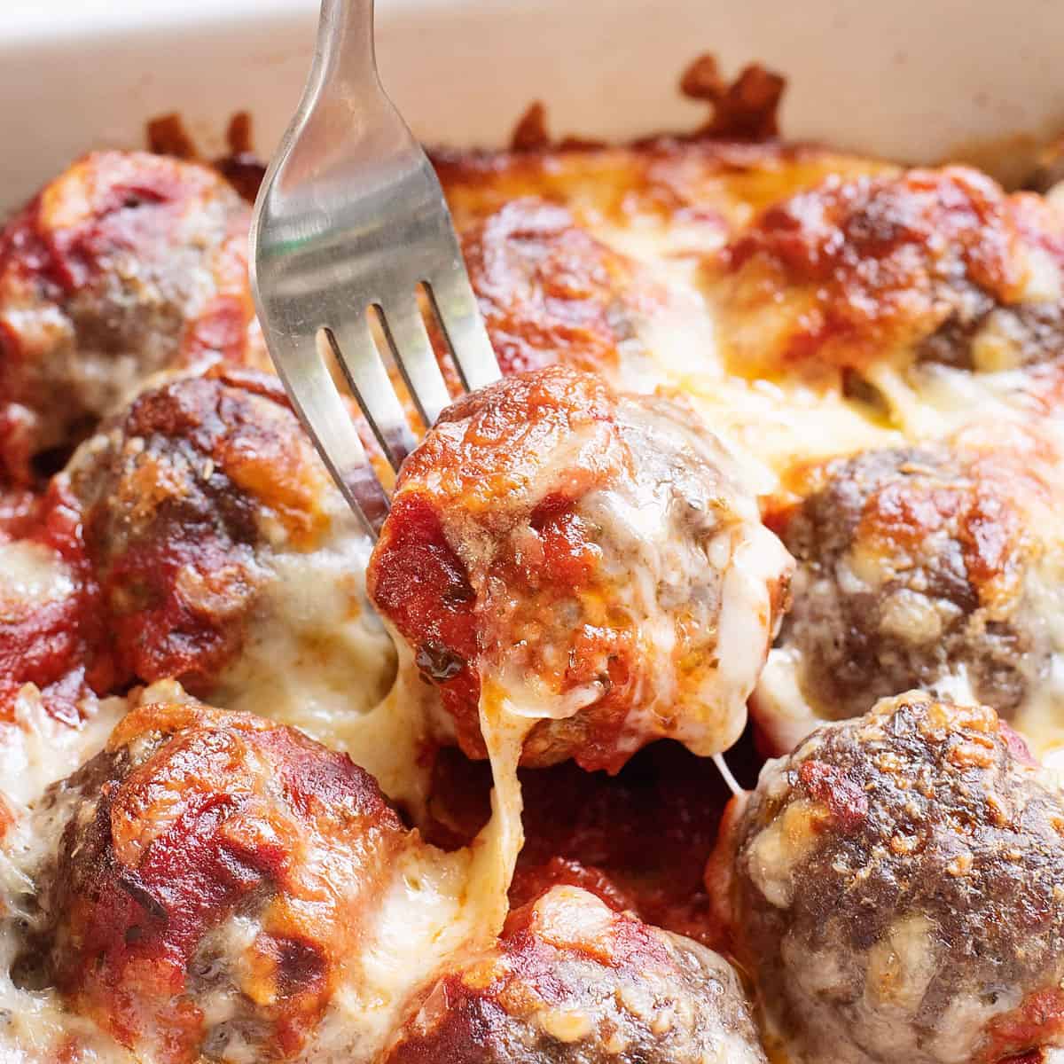 cheesy meatball sub casserole in baking dish with fork