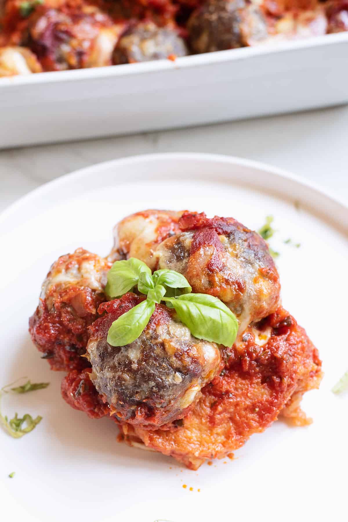 meatball sub casserole served on white plate with basil