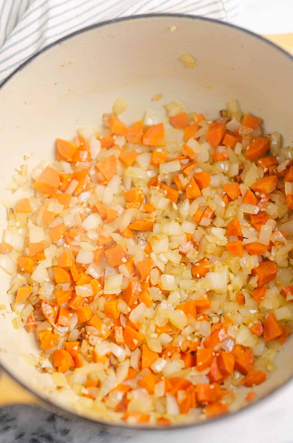 carrots and onions sauteed in yellow pot