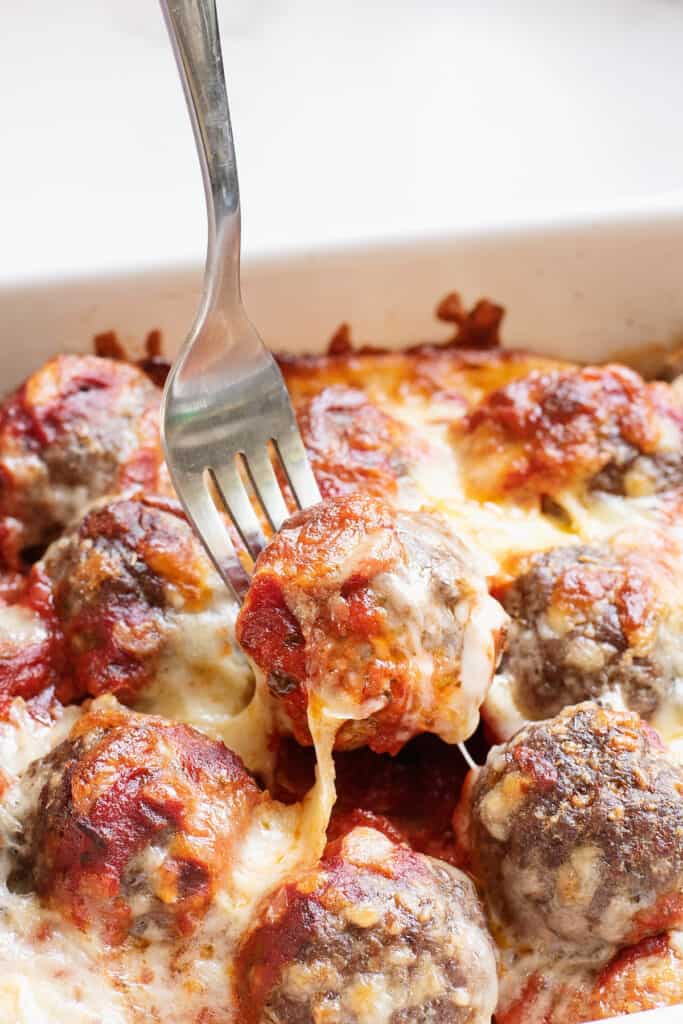 fork taking meatball from casserole