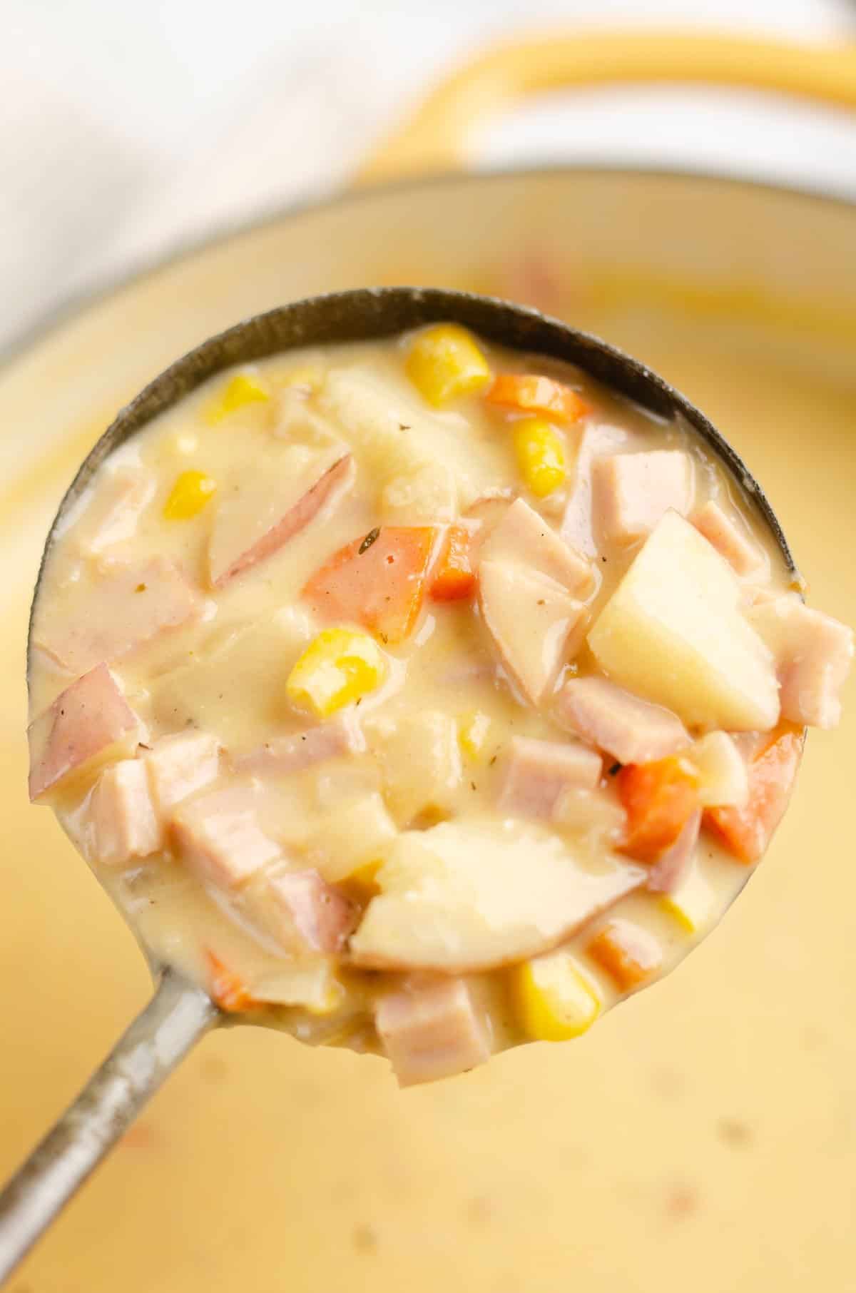 creamy ham and potato soup in ladle over pot