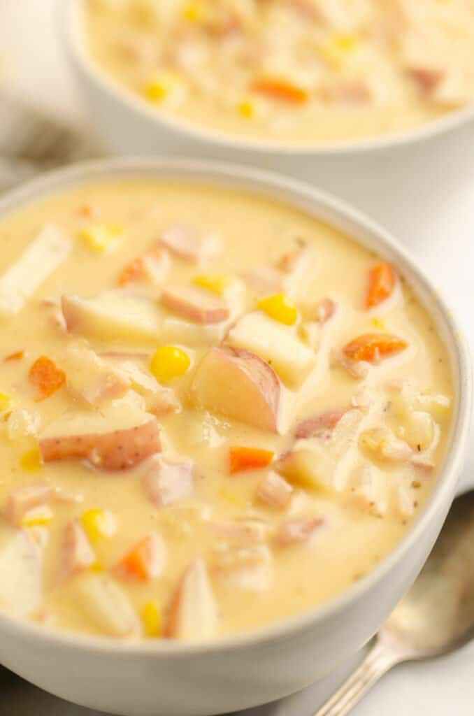 bowl of creamy ham and potato soup bowl and spoon on table