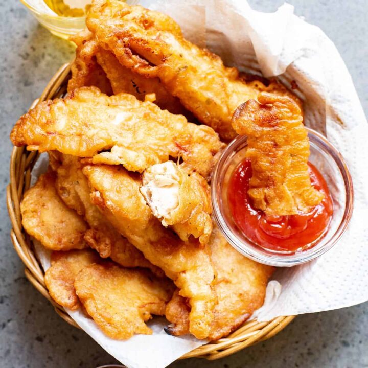 beer battered chicken tenders in lined basked with bowl of ketchup