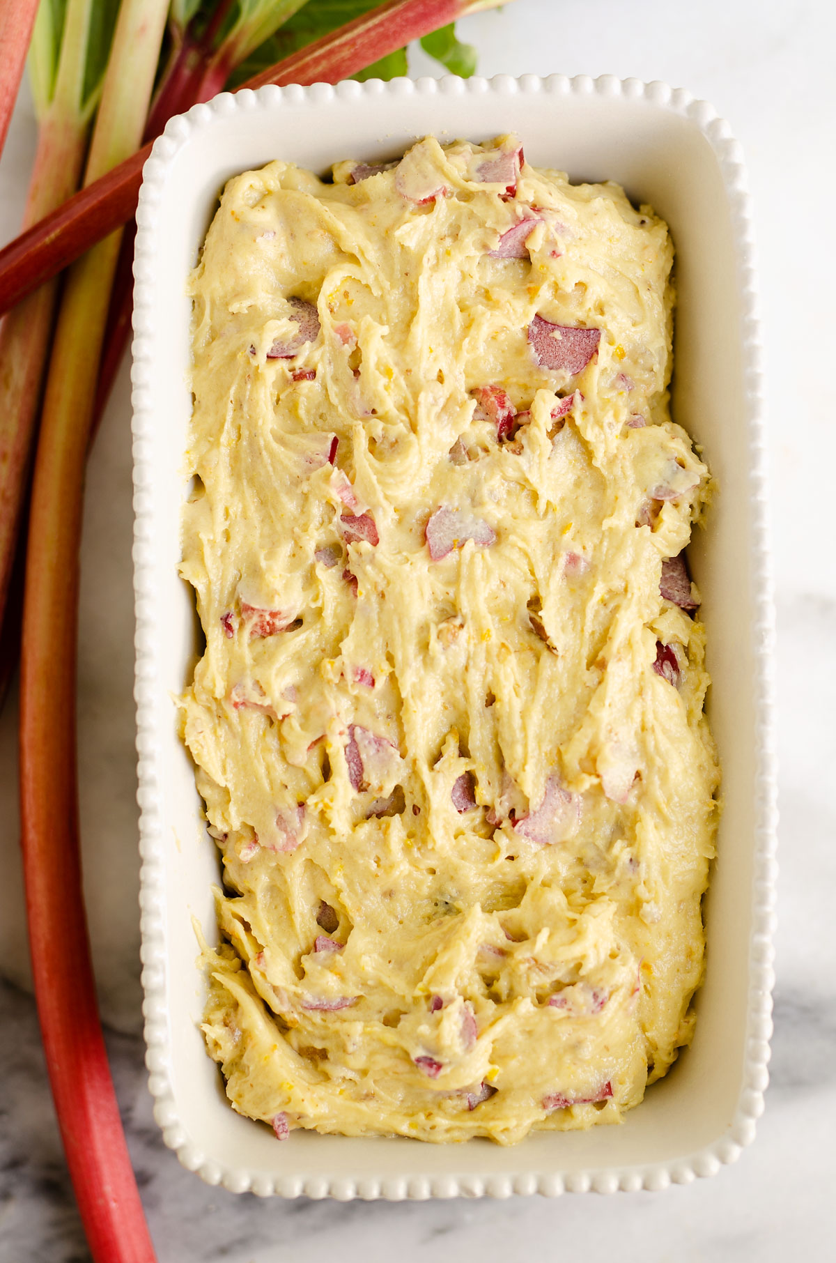 rhubarb walnut orange bread batter in white loaf pan