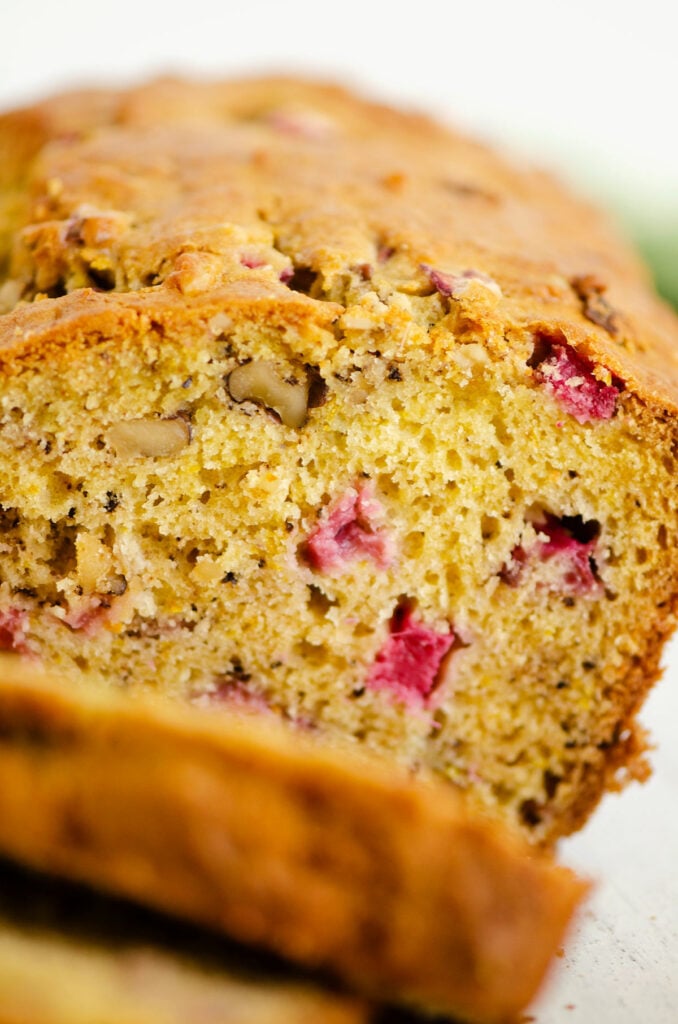 rhubarb walnut orange bread sliced on white cutting board