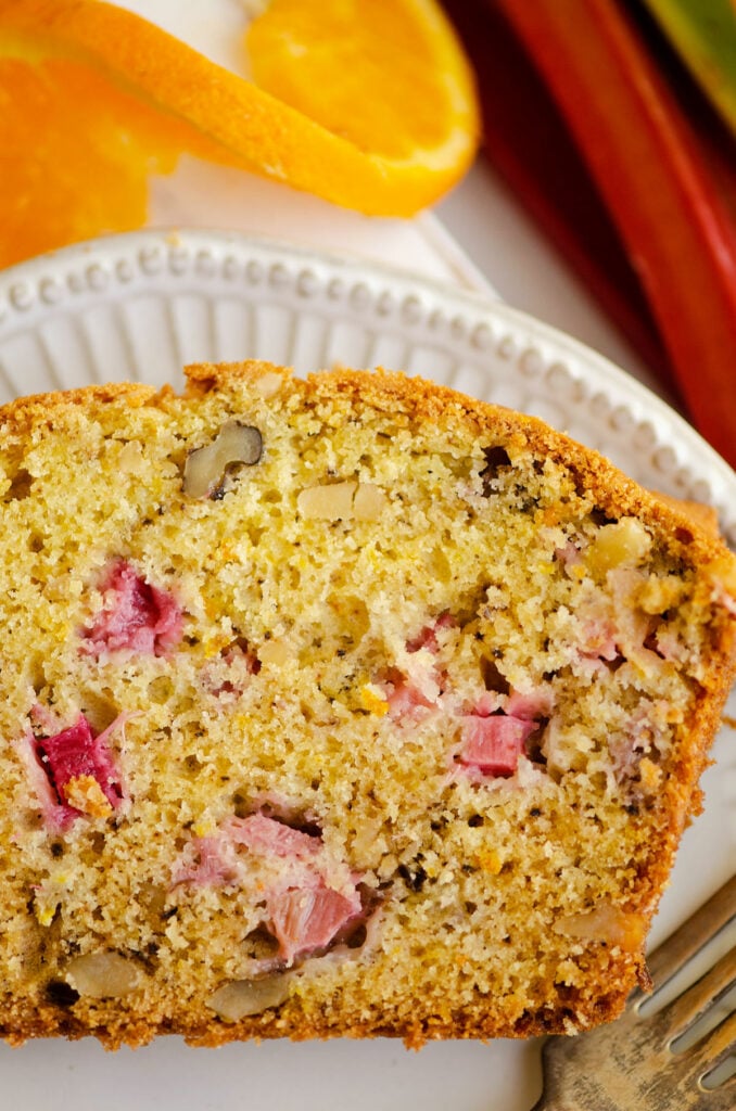 rhubarb walnut bread on plate with orange slice