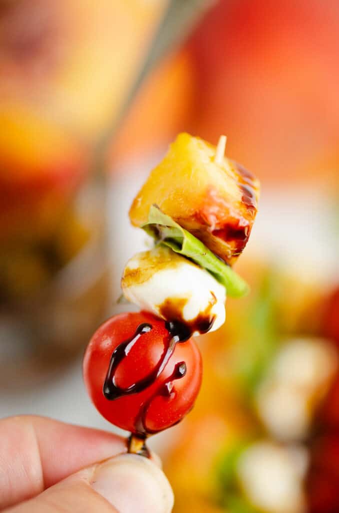 peach, basil, mozzarella and tomato on toothpick with balsamic glaze drizzle