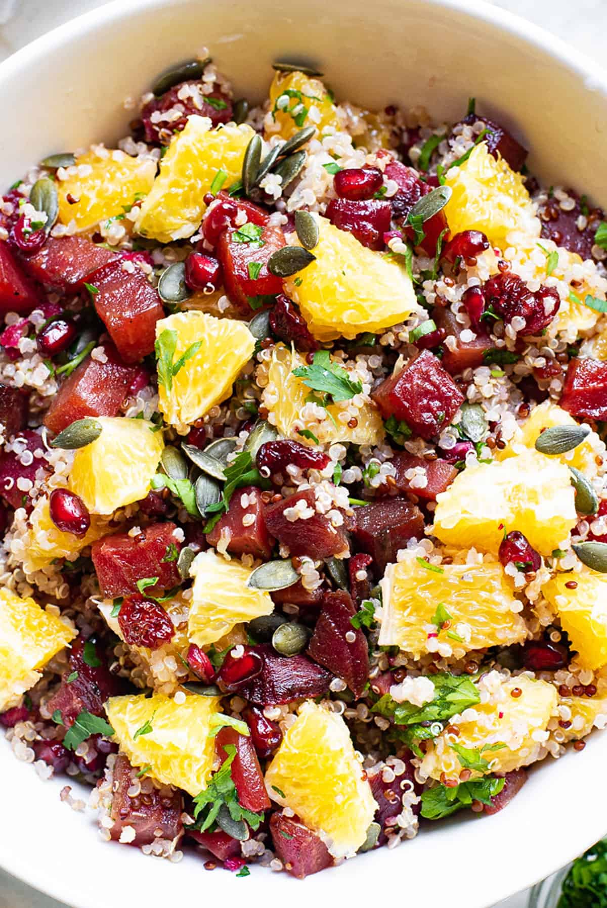 Beet & Orange Quinoa Salad with pomegranates and parsley in bowl