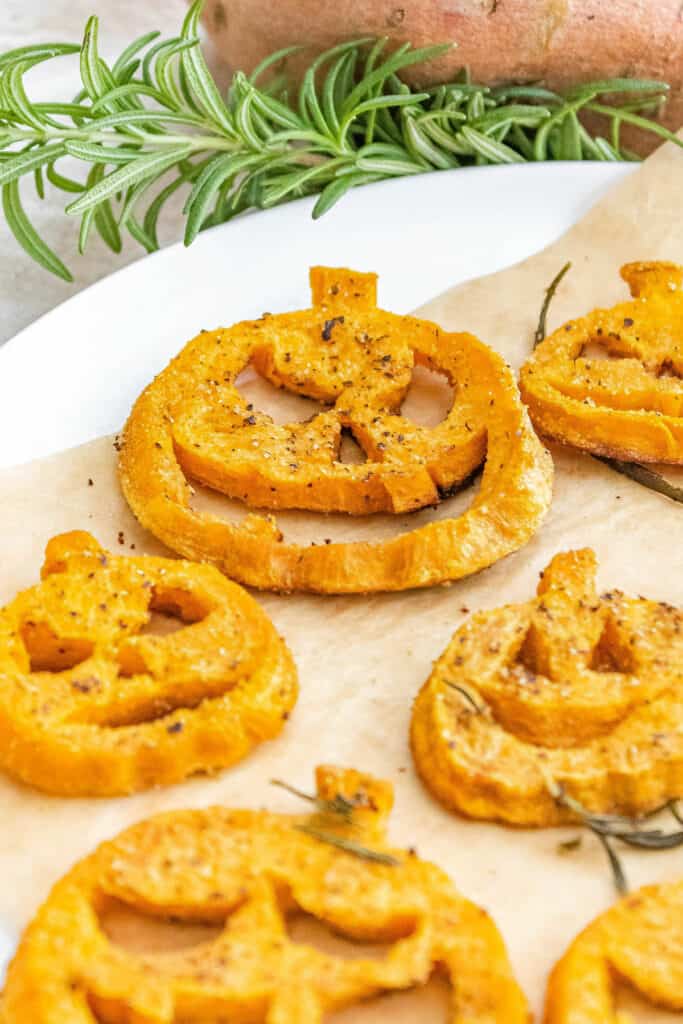 jack o lantern roasted sweet potato on parchment lined plate with herbs
