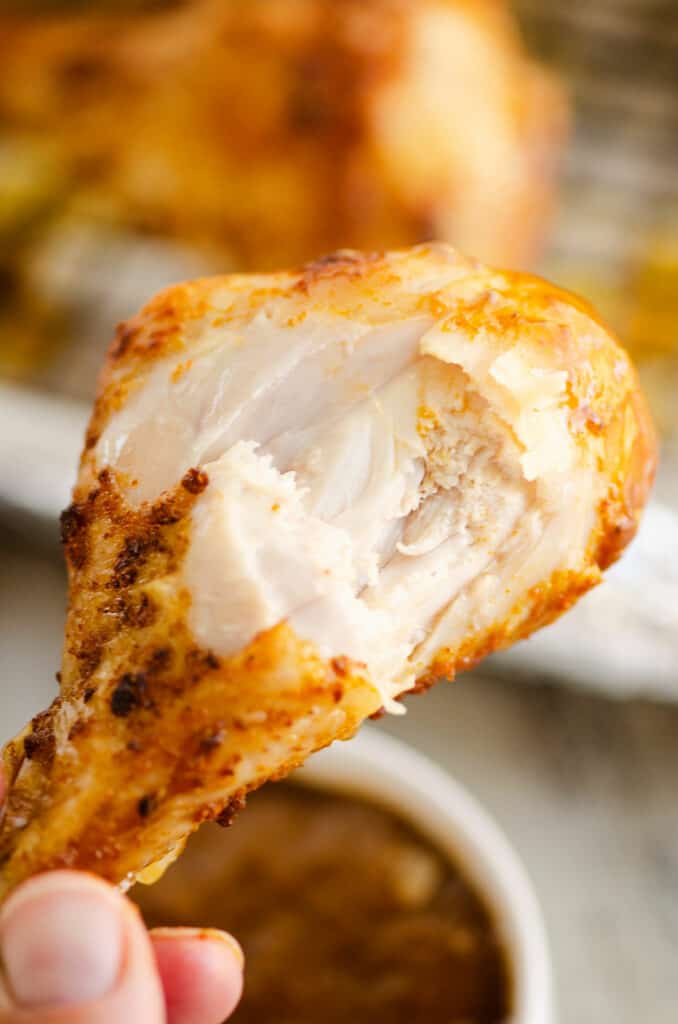bite out of tender and juicy baked chicken leg