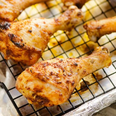 oven baked chicken legs on cookie sheet with cooling rack