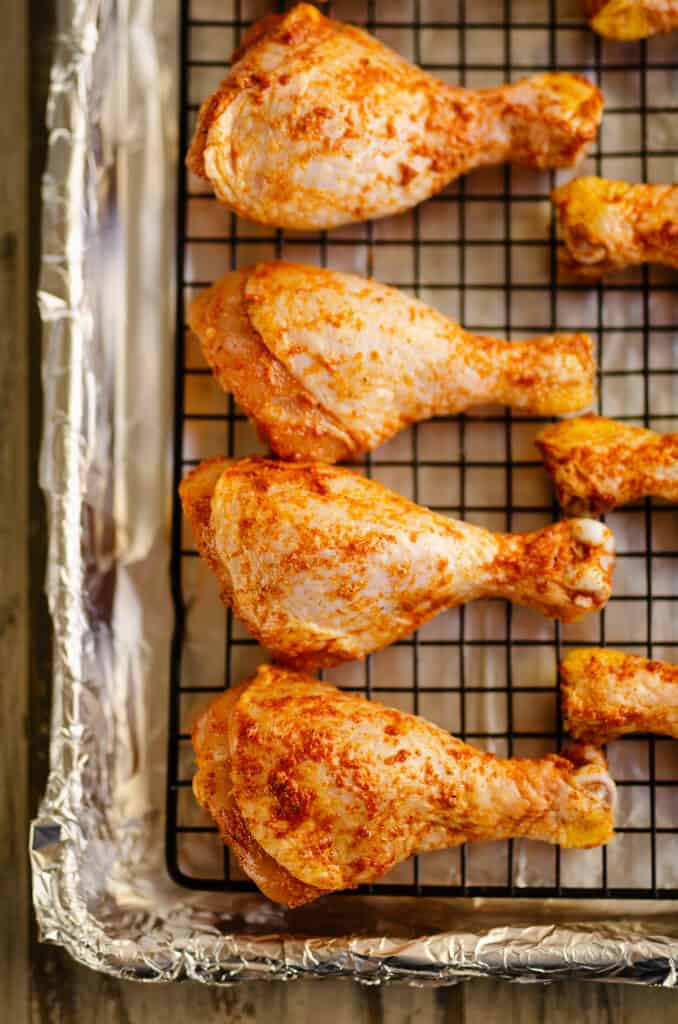 seasoned chicken legs on baking sheet
