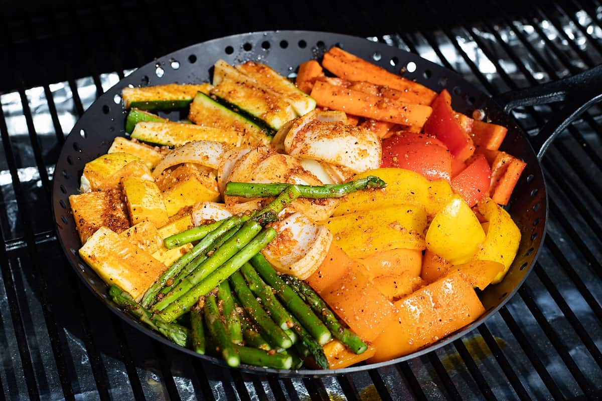 vegetables in grill basket on smoker grate