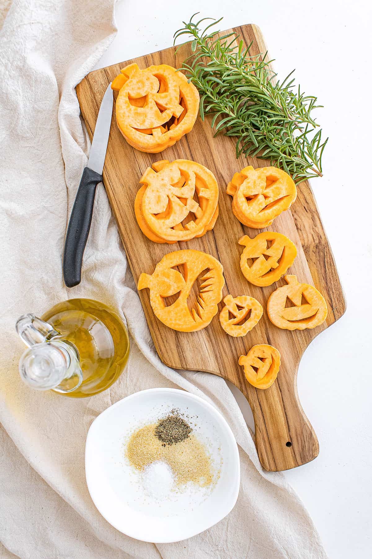 jack o lanterns cut from sweet potatoes on cutting board