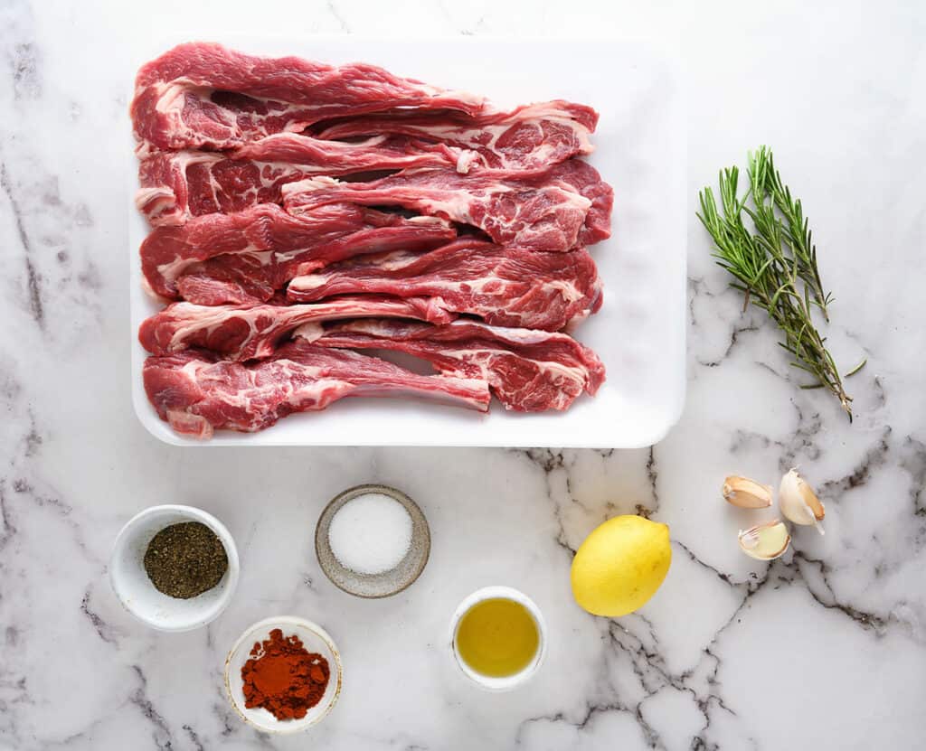 lamb chops and ingredients on marble table