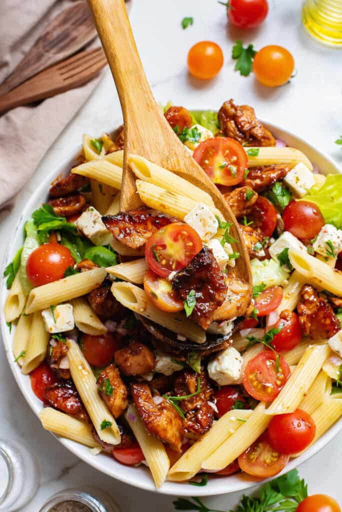 salad spoon in bowl with bbq chicken pasta salad