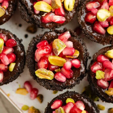 Mini Pomegranate Chocolate Tarts topped with pistachios