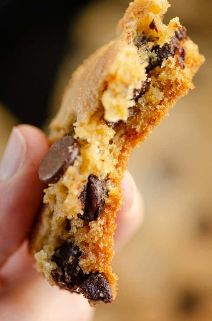 piece of skillet chocolate chip cookie in hand