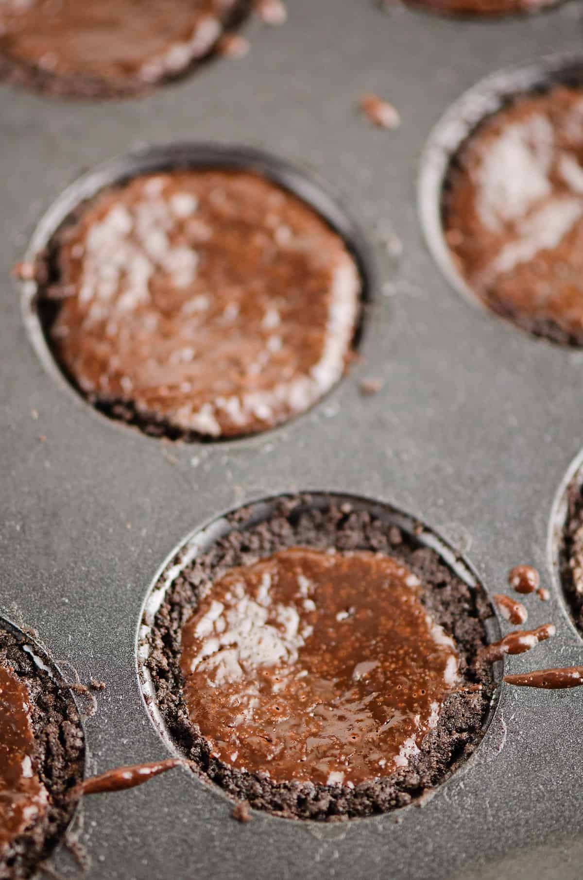 baked mini chocolate ganache tarts in muffin tin