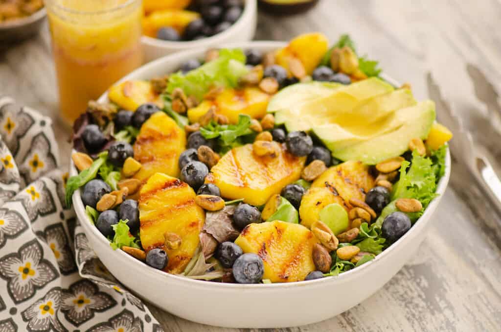Grilled Pineapple salad with sliced avocado and blueberries in bowl