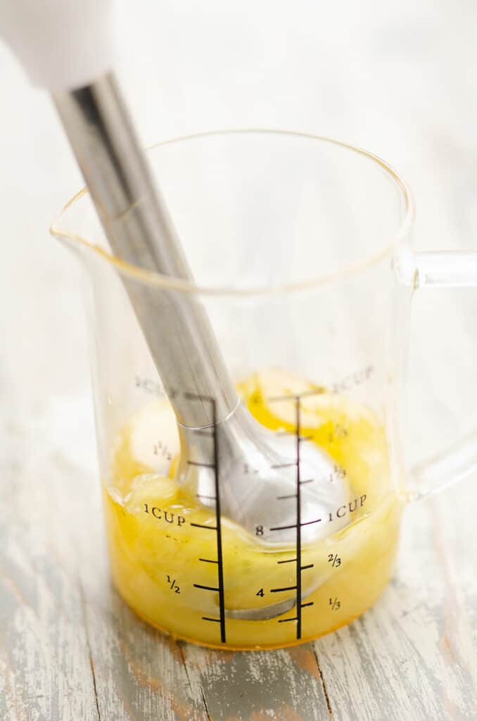 pineapple vinaigrette blended in measuring cup with immersion blender