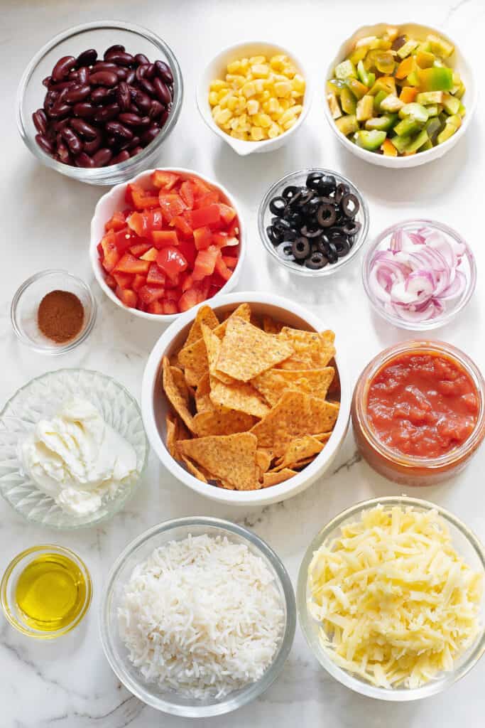 Dorito casserole ingredients on table in bowls