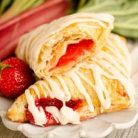 strawberry rhubarb turnovers drizzled with frosting on plate