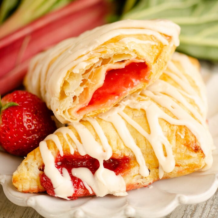strawberry rhubarb turnovers drizzled with frosting on plate