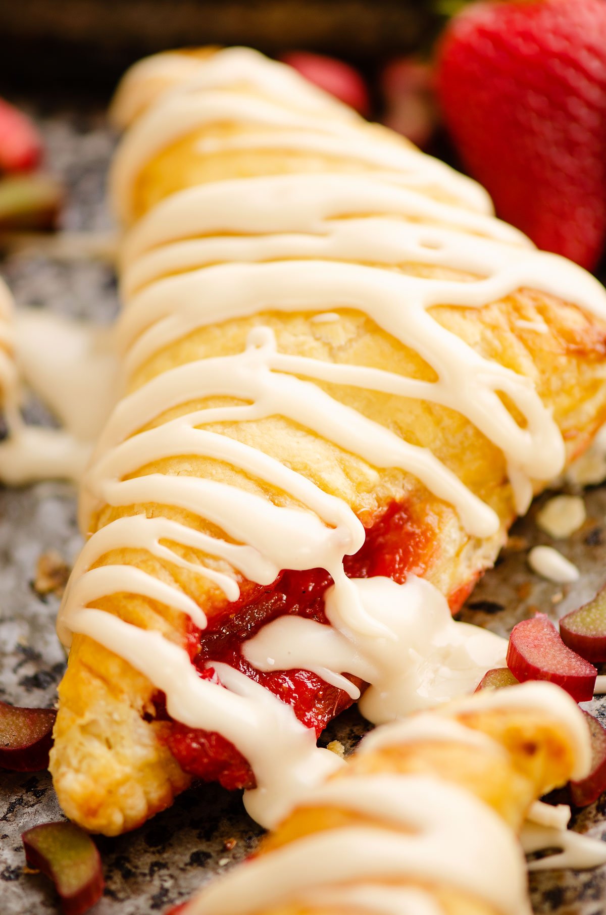 strawberry rhubarb turnover with frosting on pan
