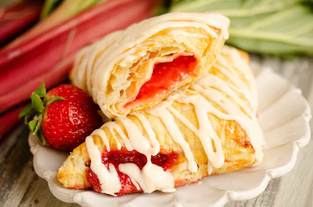strawberry rhubarb turnovers stacked on plate with bite taken out
