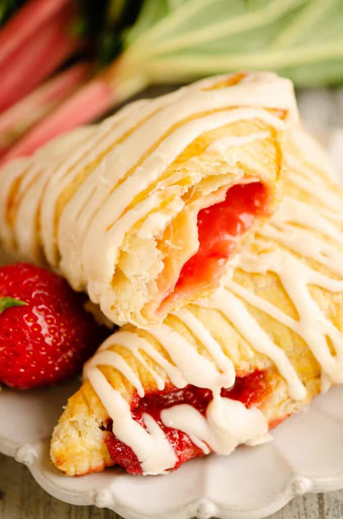 strawberry rhubarb turnovers stacked on plate with bite taken out