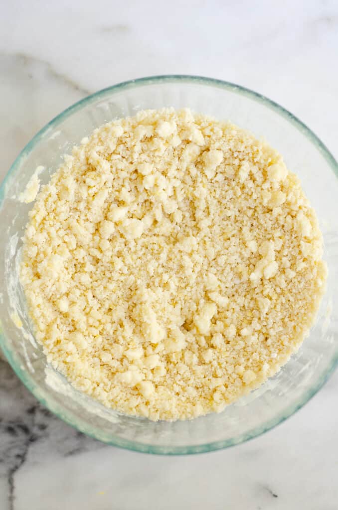 crumbly sugar cookie crust mixture in bowl