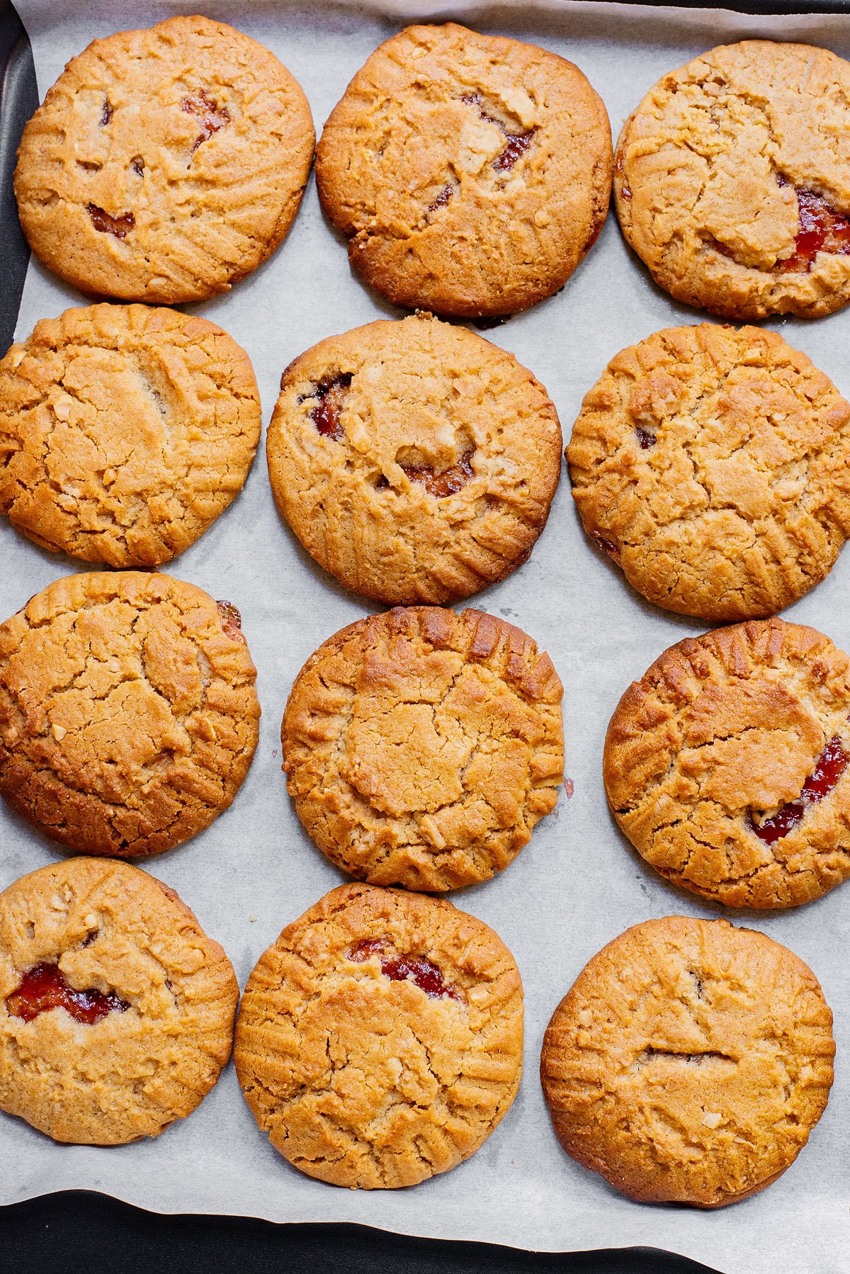 peanut butter jelly cookies on parchment lined baking sheet