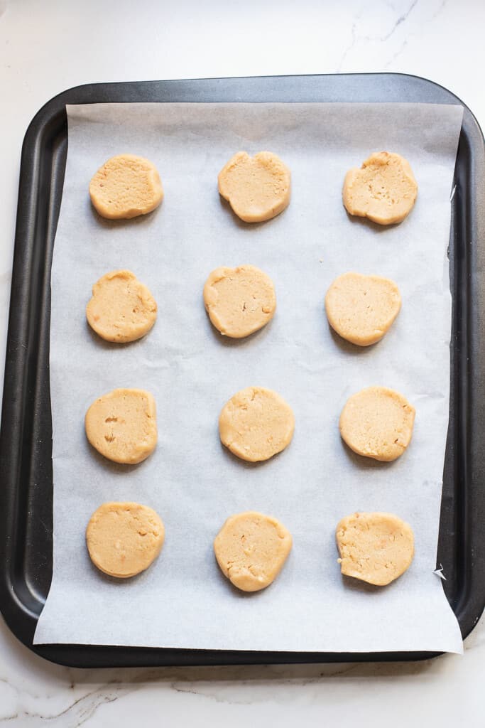 sliced peanut butter cookie dough on cookie sheet