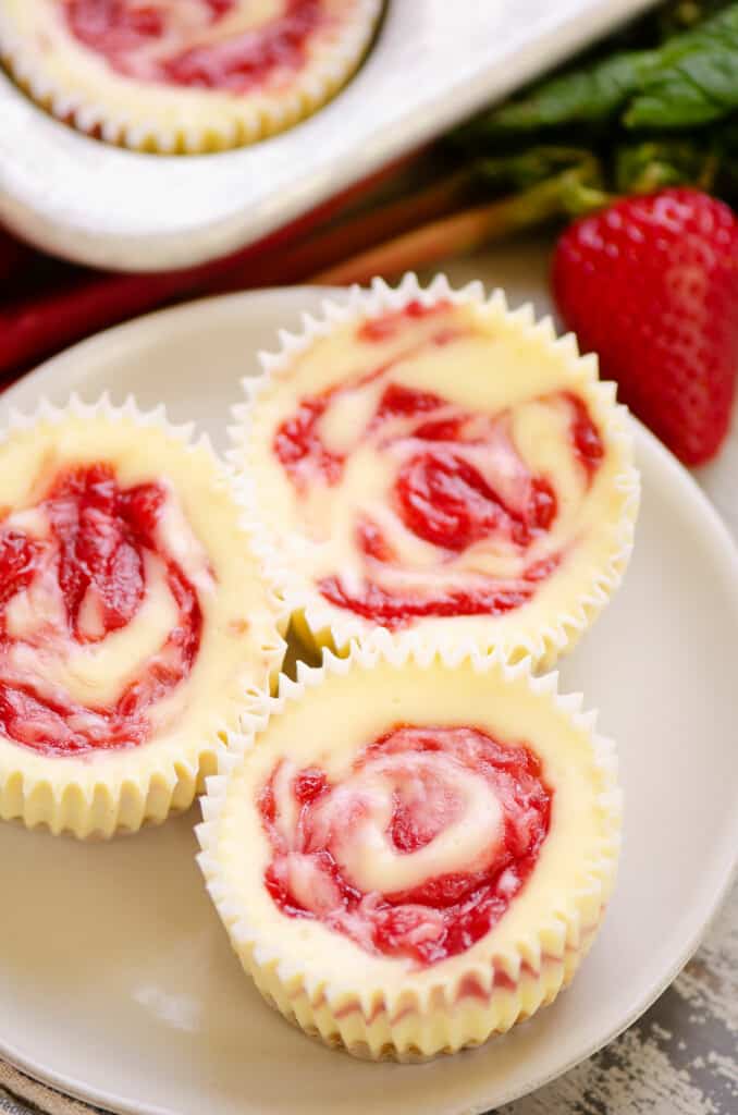 plate of three strawberry rhubarb mini cheesecakes