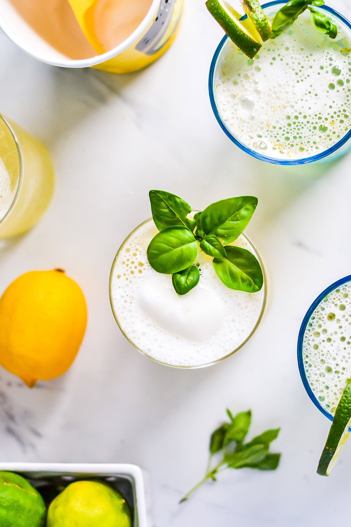 lemon punch glass on table with fruit and herbs