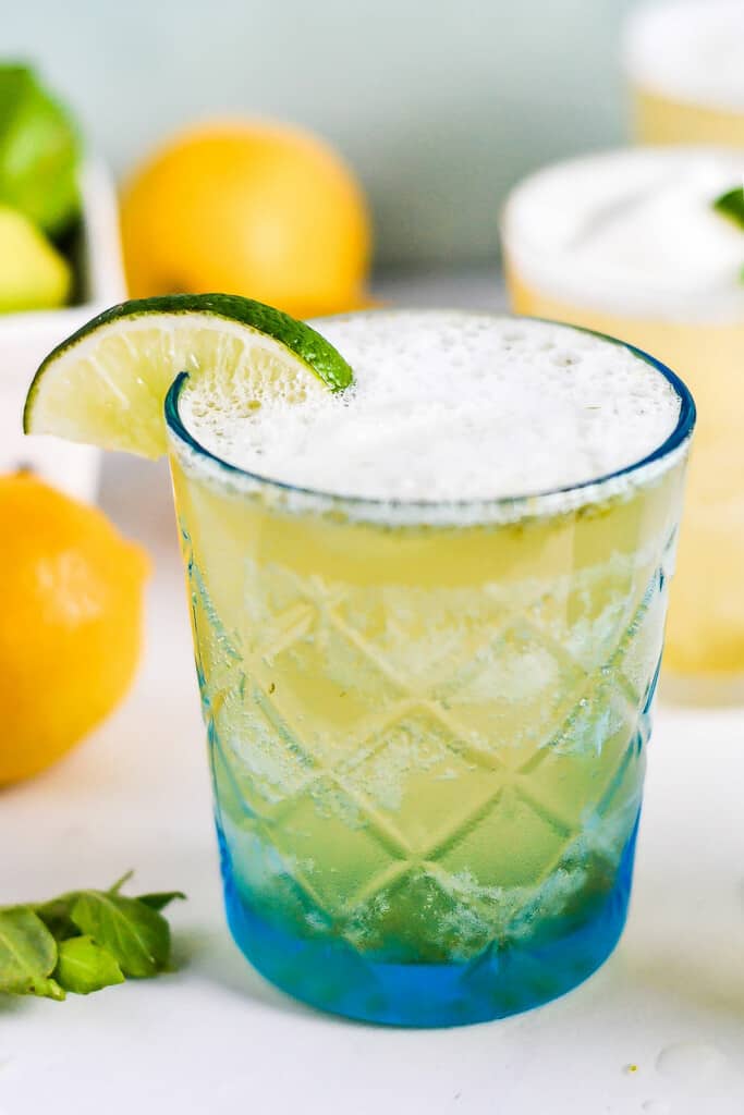 lime sherbet punch in etched glass on table with lemons